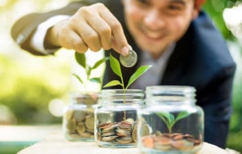 Man Placing Coins In A Jar