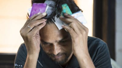 Stressed man confuse for too many card