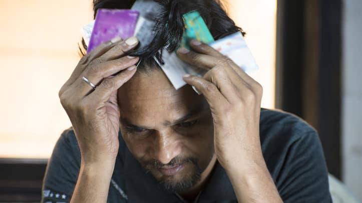Stressed man confuse for too many card