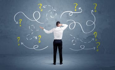 Unsure businessman with question marks