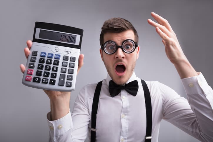 Shocked Young Man Holding Calculator