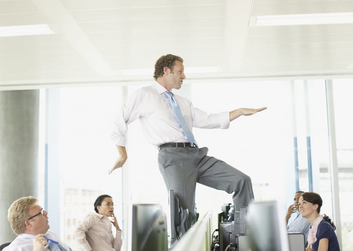 Businessman dancing on cubicle desk