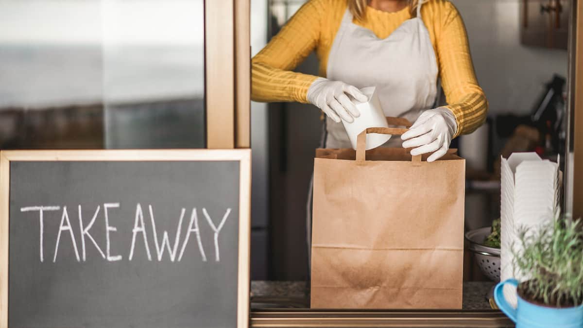 Young woman preparing takeaway healthy food inside restaurant during Coronavirus outbreak time