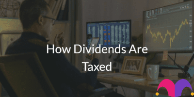 Person in front of the computer with the text "How Dividends Are Taxed" and the Motley Fool Logo
