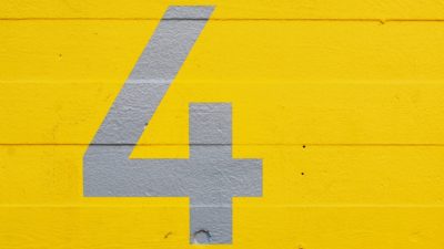 Grey Number 4 Stencil on Yellow Concrete Wall