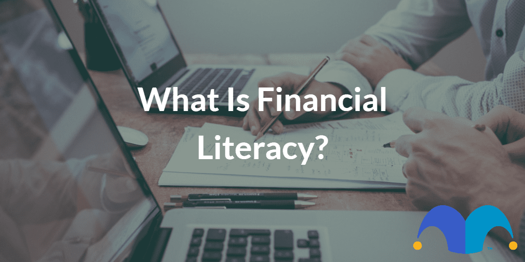Pair of people working on laptop with the text “What is financial literacy?” and The Motley Fool jester cap logo