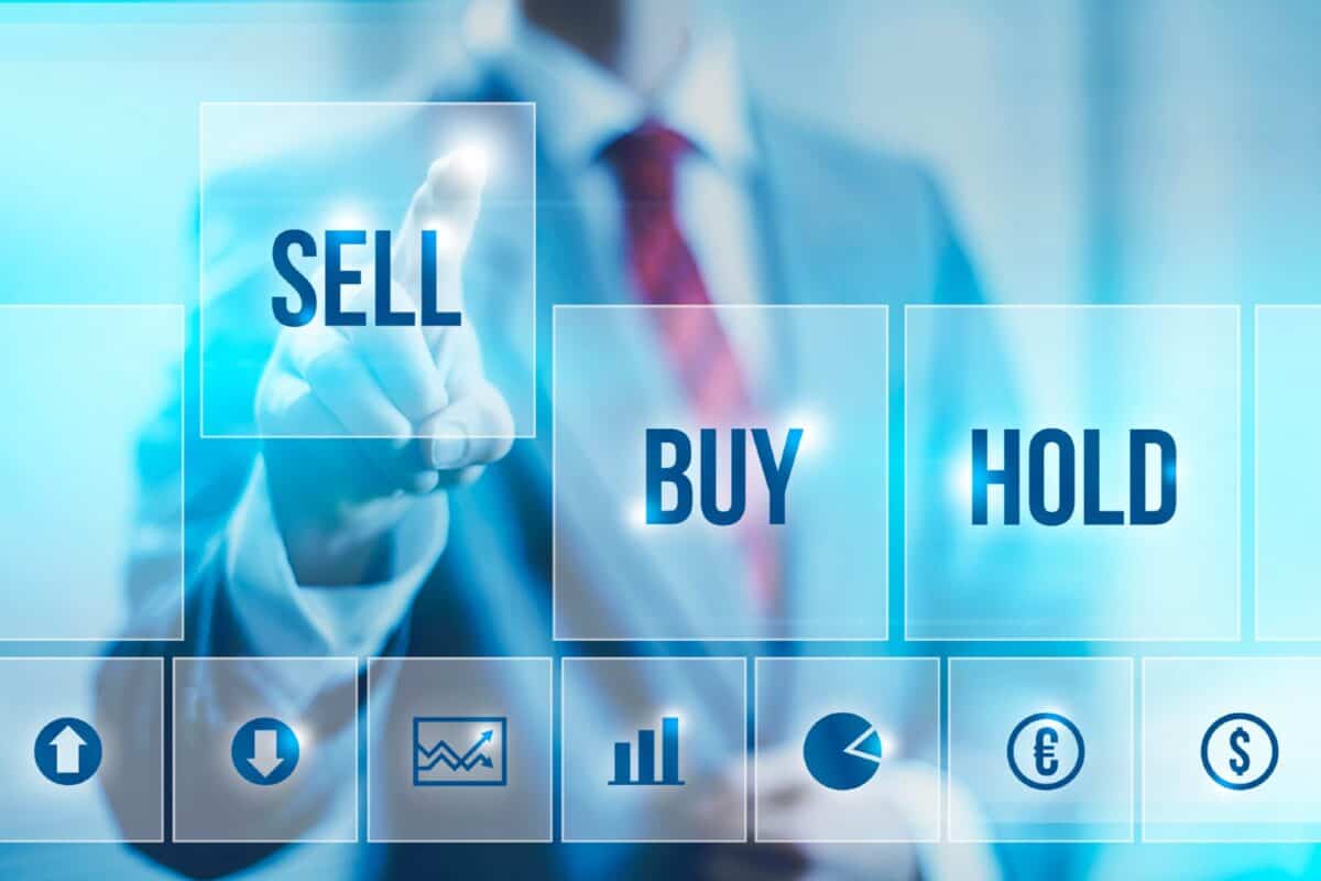 Business man pointing at 'Sell' sign